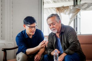 Vater und Sohn besprechen Medikamente aufgrund eines erhöhten PSA-Werts durch eine gutartige Prostatavergrößerung.